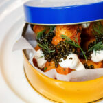 Caviar in a tin on a plate.