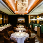 The dining room of a restaurant with a chandelier.