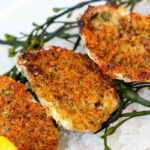 Fried oysters on ice with lemon wedges.